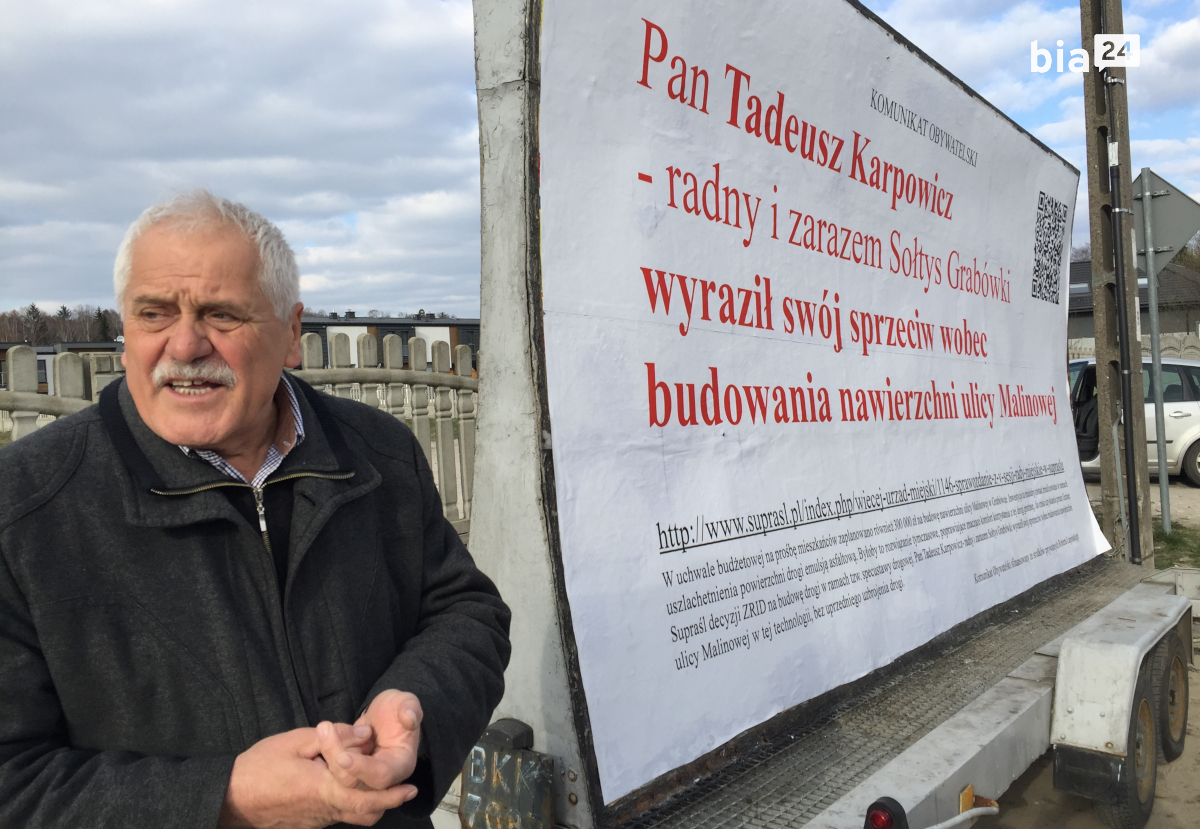 Sołtys Grabówki Tadeusz Karpowicz na&nbsp;tle billboardu