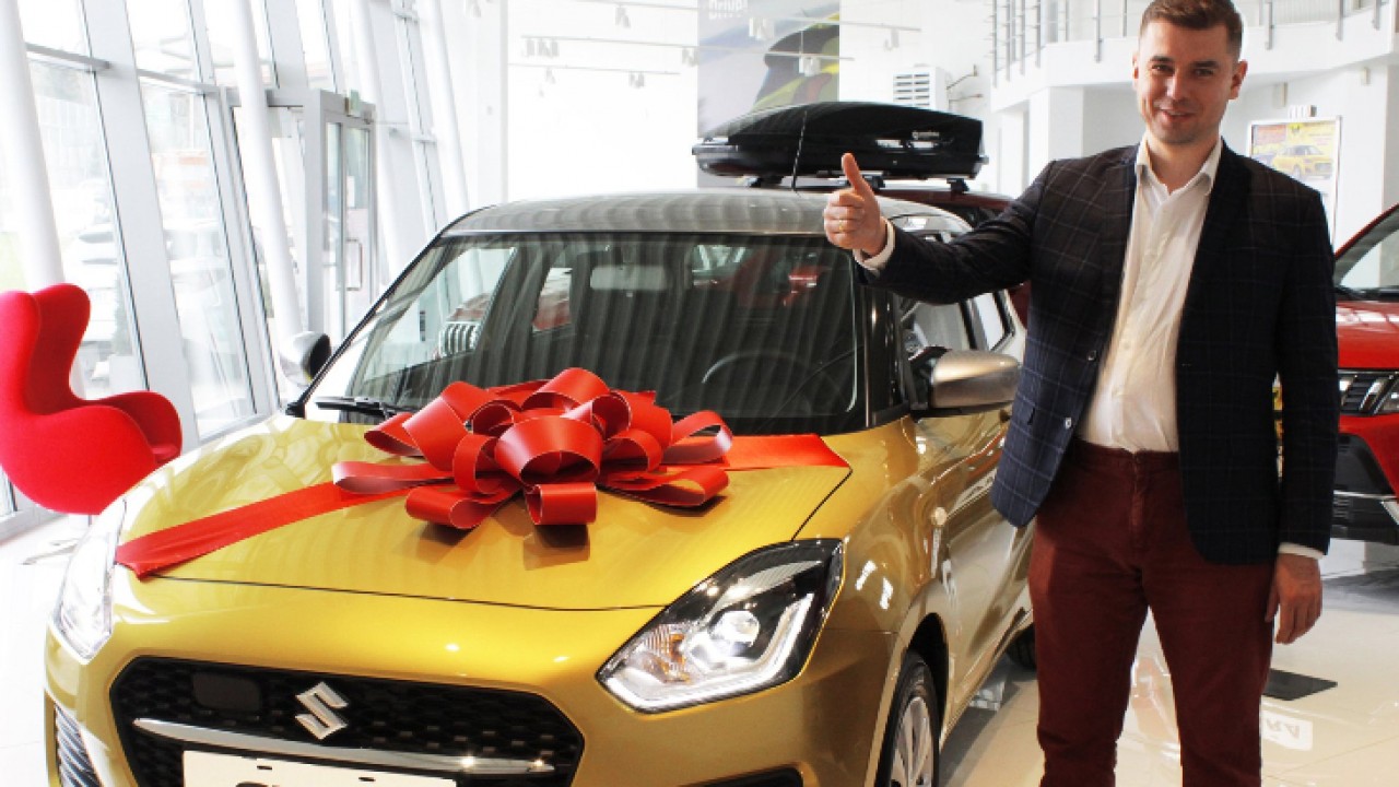 Burmistrz Adrian Łuckiewicz i główna nagroda w tegorocznej Loterii - samochód osobowy marki Suzuki Swift HYBRID/fot.  UM Wasilków