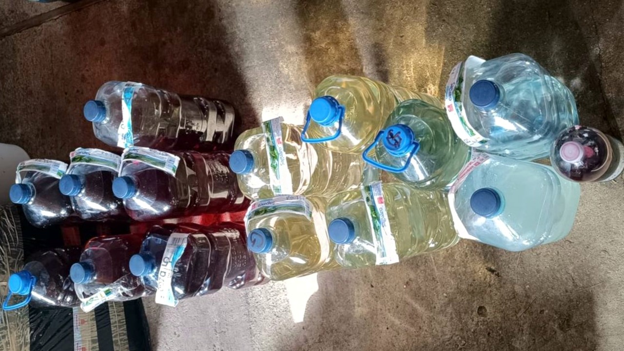 5-litrowe pojemniki wypełnione różnokolorowymi trunkami [fot. podlaska policja]